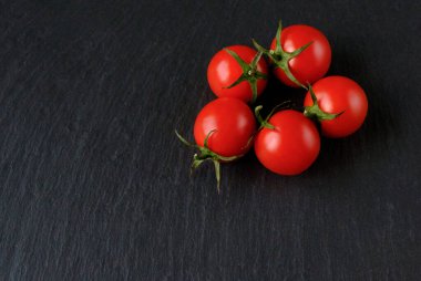 Koyu taşlı arka planda taze kırmızı domatesler. Üst Manzara. Boşluğu kopyala