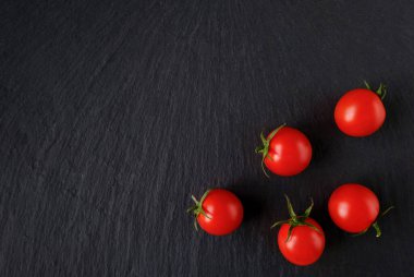 Koyu taşlı arka planda taze kırmızı domatesler. Üst Manzara. Boşluğu kopyala