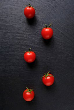 Koyu taşlı arka planda taze kırmızı domatesler. Üst Manzara. Boşluğu kopyala