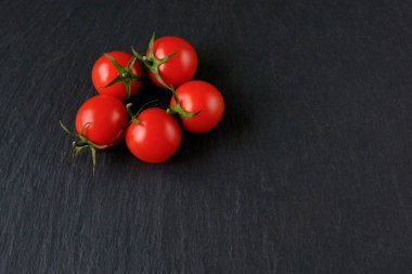 Koyu taşlı arka planda taze kırmızı domatesler. Üst Manzara. Boşluğu kopyala
