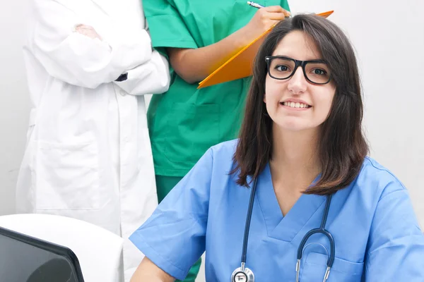 Läkare leende i förgrunden — Stockfoto