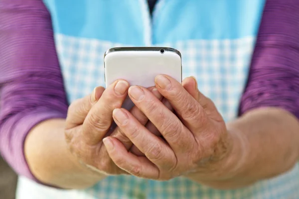 Старші руки з мобільним — стокове фото