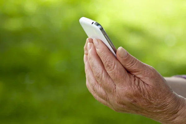 Руки старші з мобільним — стокове фото