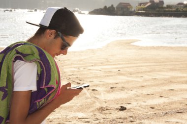 mobile ile sahilde genç çocuk