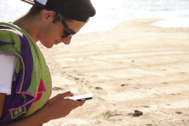 mobile ile sahilde genç çocuk