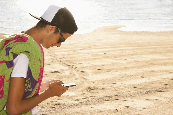 Niño en la playa con móvil — Foto de Stock