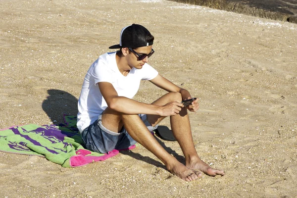 Jongetje op het strand met mobile — Stockfoto