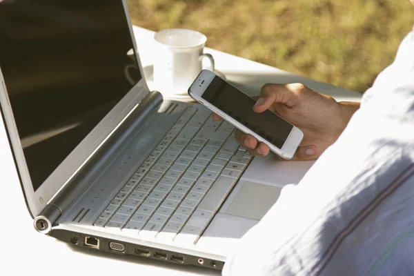 Mâini cu mobil și laptop — Fotografie, imagine de stoc