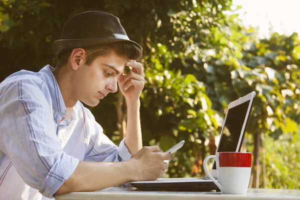 Hombre con teléfono móvil y computadora — Foto de Stock