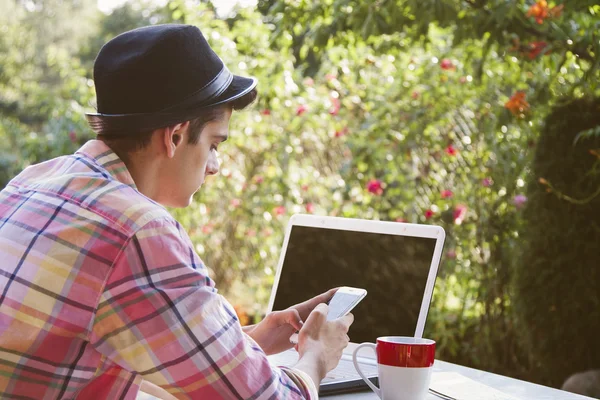 Man met mobiele telefoon en computer — Stockfoto