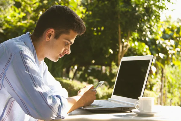 Man with mobile and laptop Stock Photo