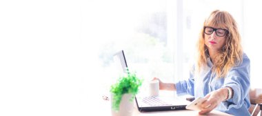 İş kadını evde ya da ofiste bilgisayar ve hesap makinesiyle çalışıyor.