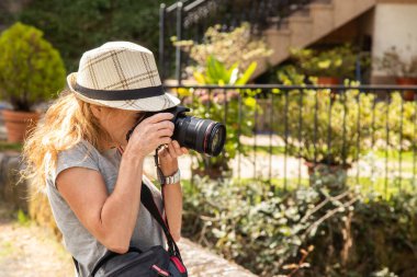 Fotoğraf makinesi olan kadın doğada fotoğraf çekiyor.