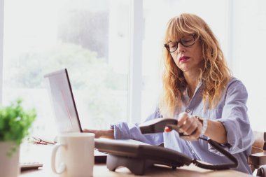 Stres ve yorgunluk ifadesi olan iş kadını görevinde.