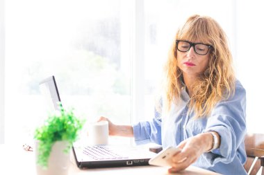 İş kadını evde ya da ofiste bilgisayar ve hesap makinesiyle çalışıyor.