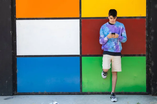 Adolescente Maschio Con Cellulare Alla Porta Colorata — Foto Stock