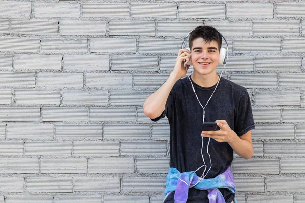 Adolescente Con Teléfono Móvil Auriculares Pared Calle —  Fotos de Stock
