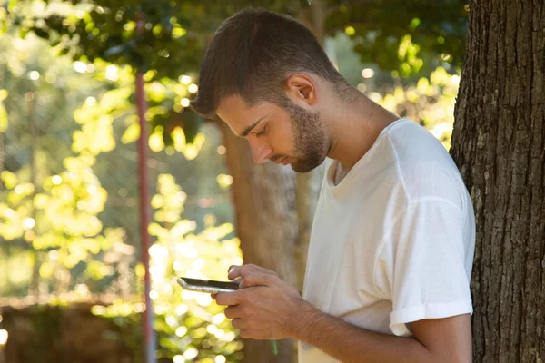 Jonge Man Zoek Naar Mobiele Telefoon Typen Profiel Uitzicht Buiten — Stockfoto