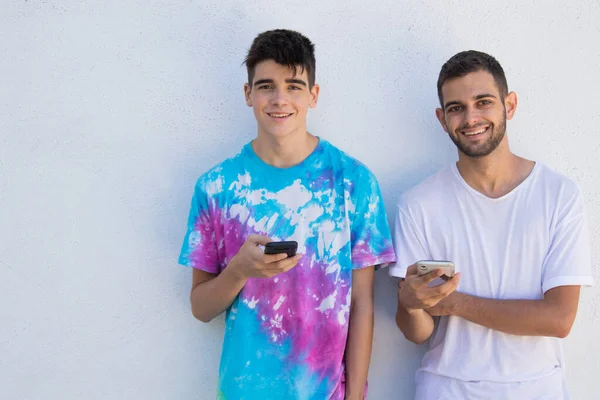 young couple with mobile phones in the city on the street outdoors