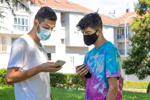 young people with mask and mobile phone outdoors