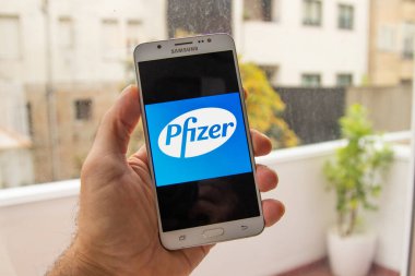 Galiçya, İspanya - 14 Kasım 2020: cep telefonu ekranında pfizer ilaç şirketi logosu