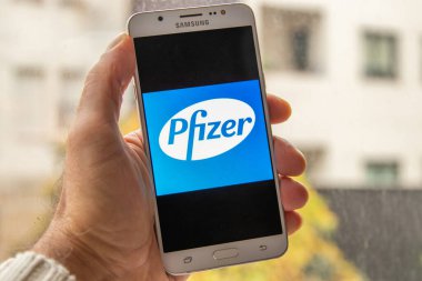 Galiçya, İspanya - 14 Kasım 2020: cep telefonu ekranında pfizer ilaç şirketi logosu