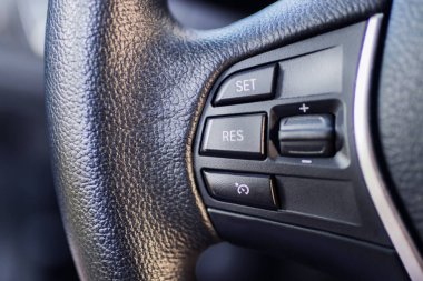 Ön planda dümen kontrolü olan araba direksiyonu.