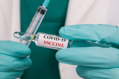 Coronavirus aşısı ve şırınga ile eller
