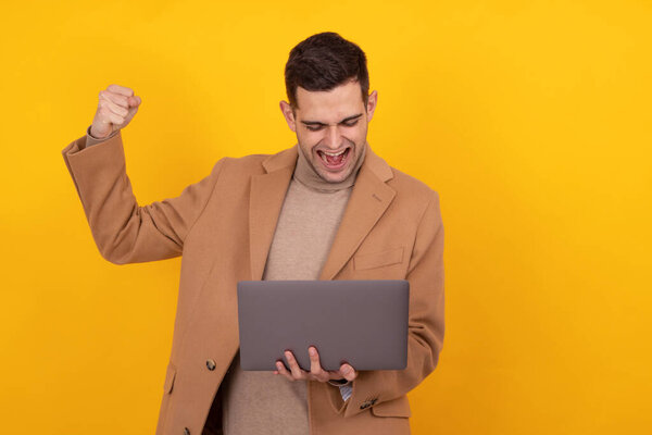 successful young man with computer isolated on background