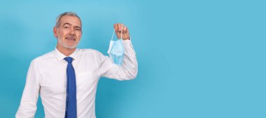 Arka planda yüz maskesi olan yetişkin ya da yaşlı adam