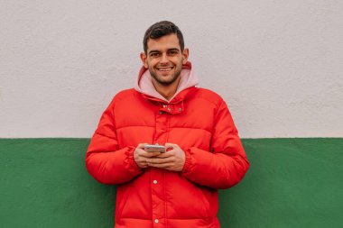 Duvarında cep telefonu olan genç bir adam. Mesaj veya reklam için yeri var.