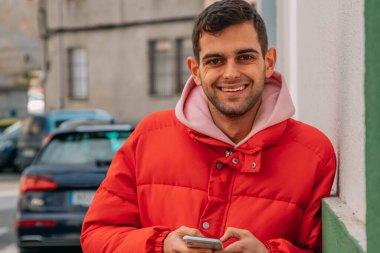 Şehir sokaklarında cep telefonu olan genç bir adam.