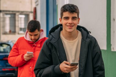 Dışarıda telefonlu öğrenciler.