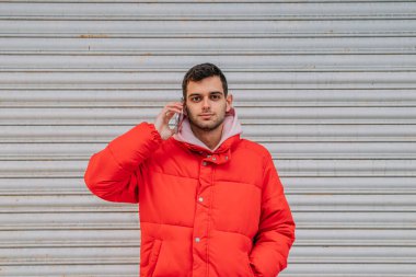 Şehirde cep telefonu olan genç bir adam.