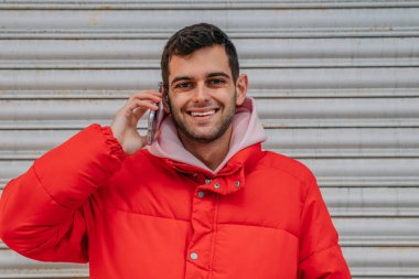 Genç adam cep telefonuyla konuşuyor.