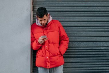 Şehirde cep telefonu olan genç bir adam.