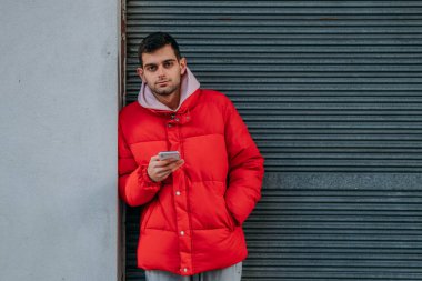 Şehirde cep telefonu olan genç bir adam.