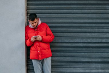 Şehirde cep telefonu olan genç bir adam.