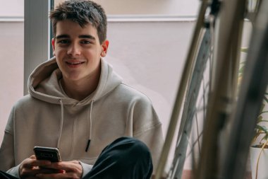 Evde cep telefonu kullanan genç bir kız.