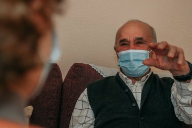 Koronavirüs salgınında uzaktan konuşan maskeli yaşlılar