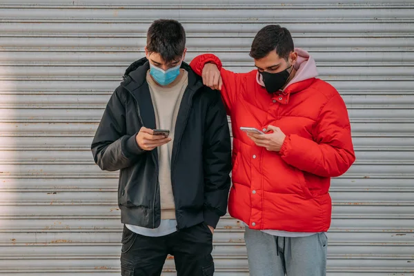 young people with mask and mobile phone on the street