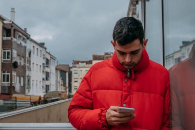 Şehirde cep telefonu ve ceketi olan bir adam var.