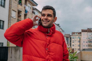 Şehirde cep telefonu ve ceketi olan bir adam var.