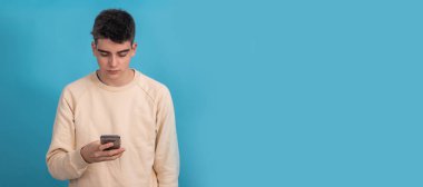 Arka planda cep telefonu olan genç erkek ya da öğrenci