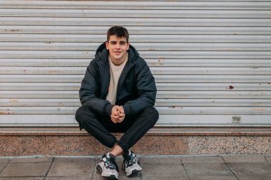 Şehirde sıradan bir genç adam oturuyor.