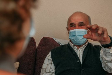 Koronavirüs salgınında uzaktan konuşan maskeli yaşlılar