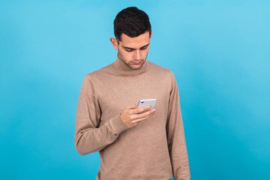 Genç adam arka planda cep telefonu ya da akıllı telefonuyla izole edildi