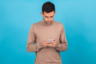 Genç adam arka planda cep telefonu ya da akıllı telefonuyla izole edildi