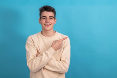 Gülümseyen genç çocuk işaret ediyor.