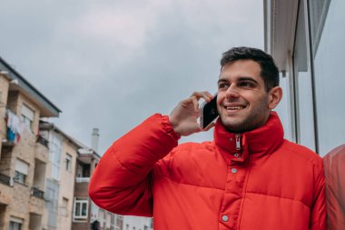 Şehirde cep telefonu olan genç bir adam.